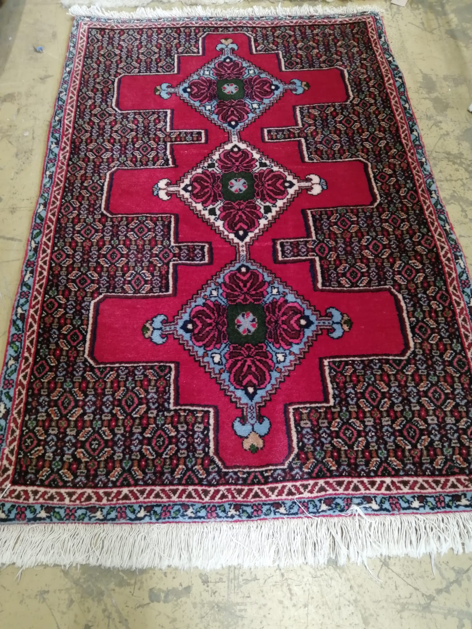 A North West Persian red ground rug, 112 x 74cm